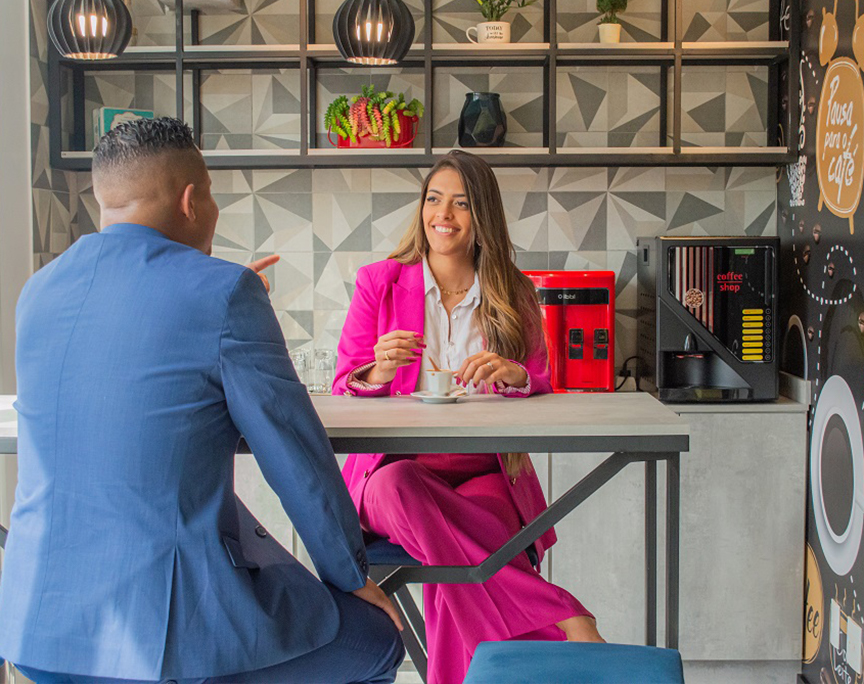Duas pessoas conversando no espaço de cafe do coworking br.offices