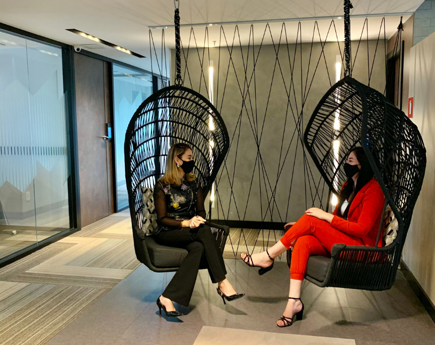 Duas mulheres conversando nos balanços do espaço de coworking br.offices